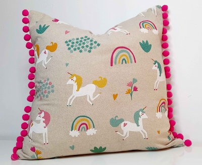 Unicorn print cushion with cerise pink pom poms. Bedroom cushion, nursery cushion, girl's bedroom.