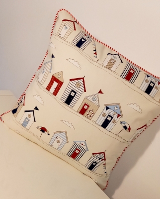 'Barassie' cushion featuring a beach hut design and stiped piping.