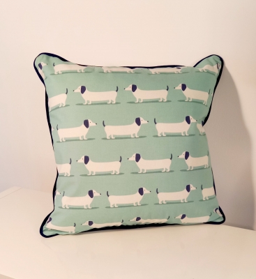 'Dash The Dog' cushion featuring a dachshund dog design with navy piping detail.